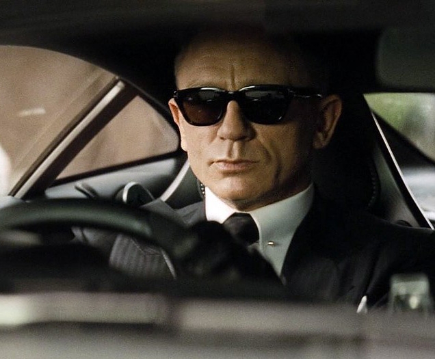 Daniel Craig as James Bond, wearing Tom Ford Snowdon sunglasses in SPECTRE, while driving his Aston Martin DB10.
