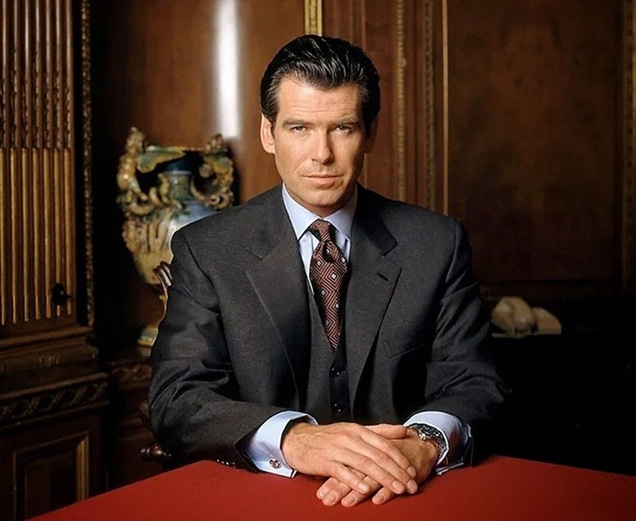 Pierce Brosnan wears a Brioni suit, and Turnbull & Asser shirt and tie and Dunhill cufflinks in this promotional image for Tomorrow Never Dies..