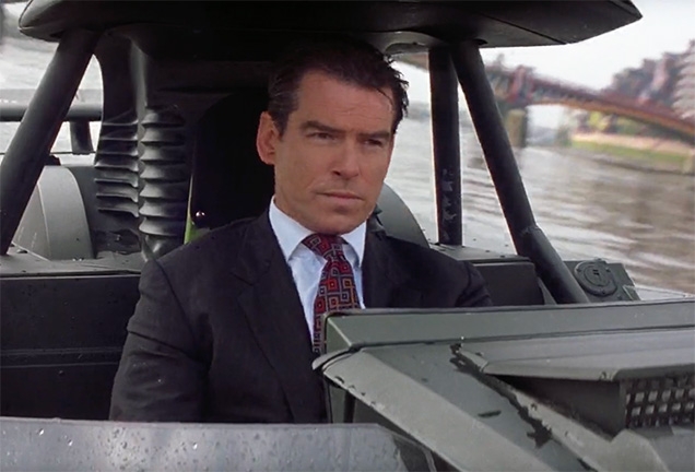 In The World Is Not Enough, Pierce Brosnan as James Bond wears a dark grey Turnbull & Asser tie with grey, tan and burnt orange square motif.
