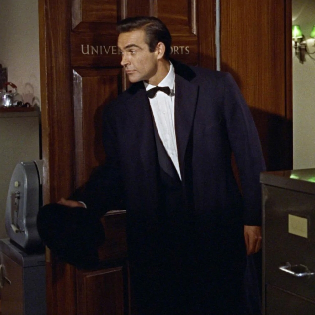 Sean Connery in the first movie Dr. No wearing the Anthony Sinclair Navy Chesterfield Overcoat